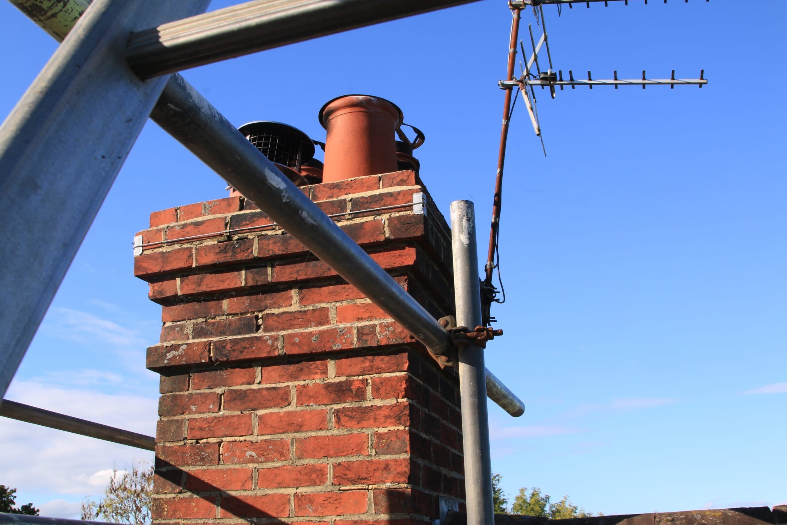 Brick chimney and pots surrounded by scaffolding