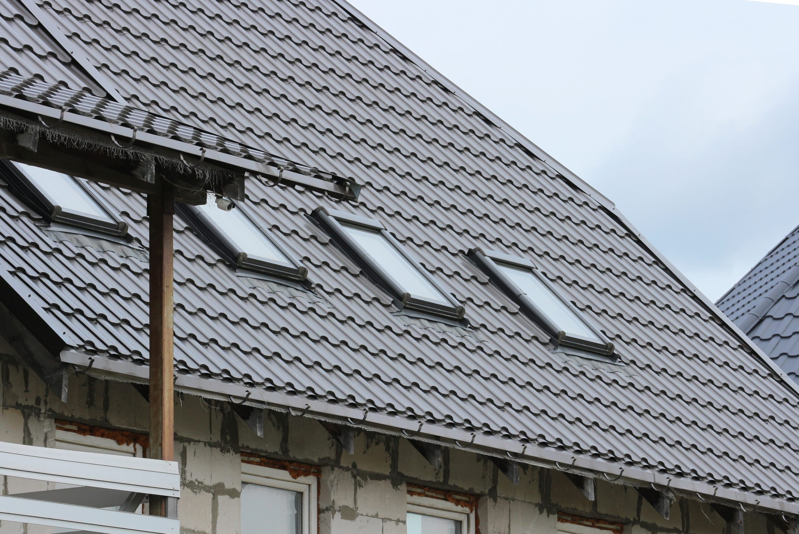 Pitched roof with fitted roof windows and sealed roofing panels