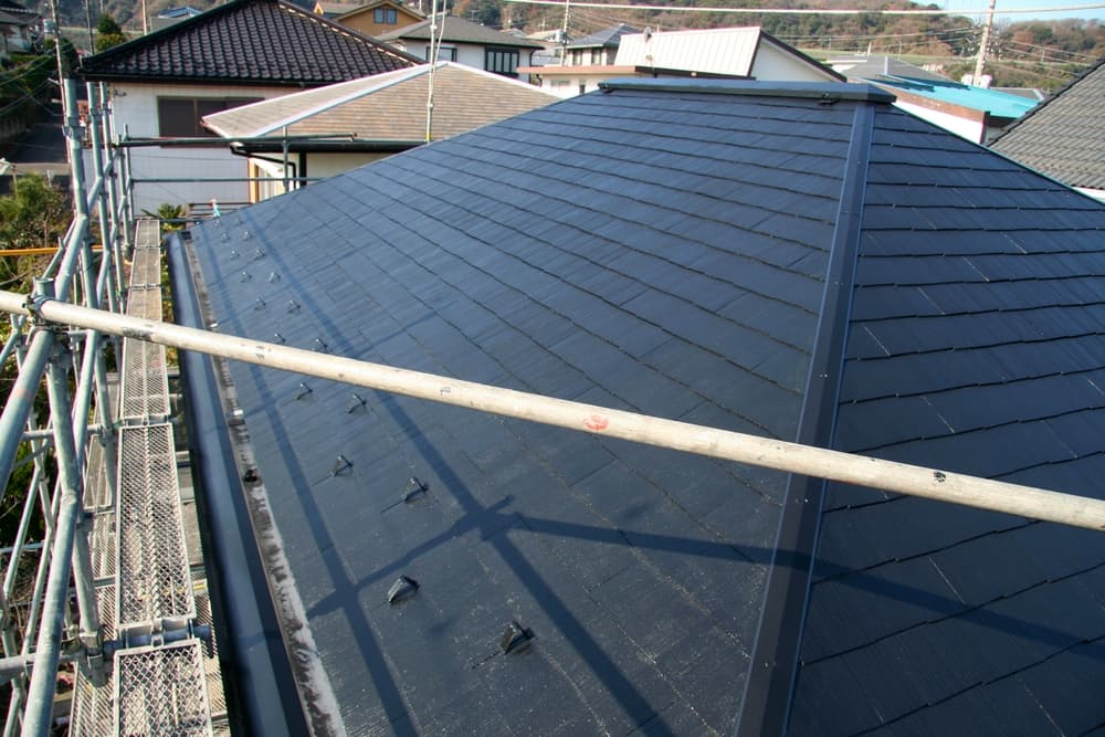 Dark pitched roof surrounded by scaffolding