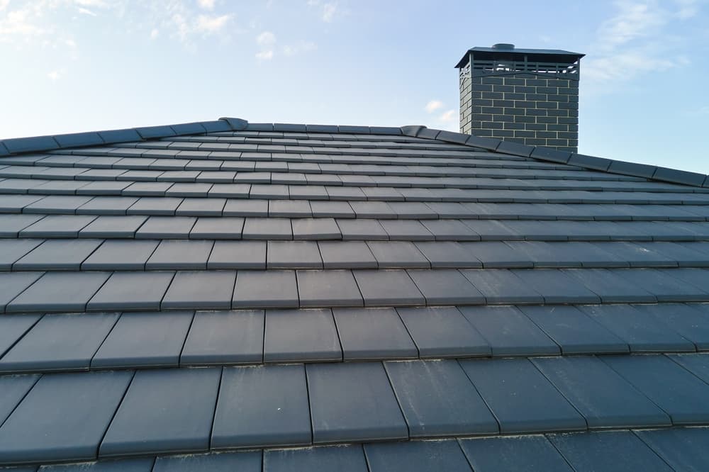 Close-up of a tiled roof and brick chimney