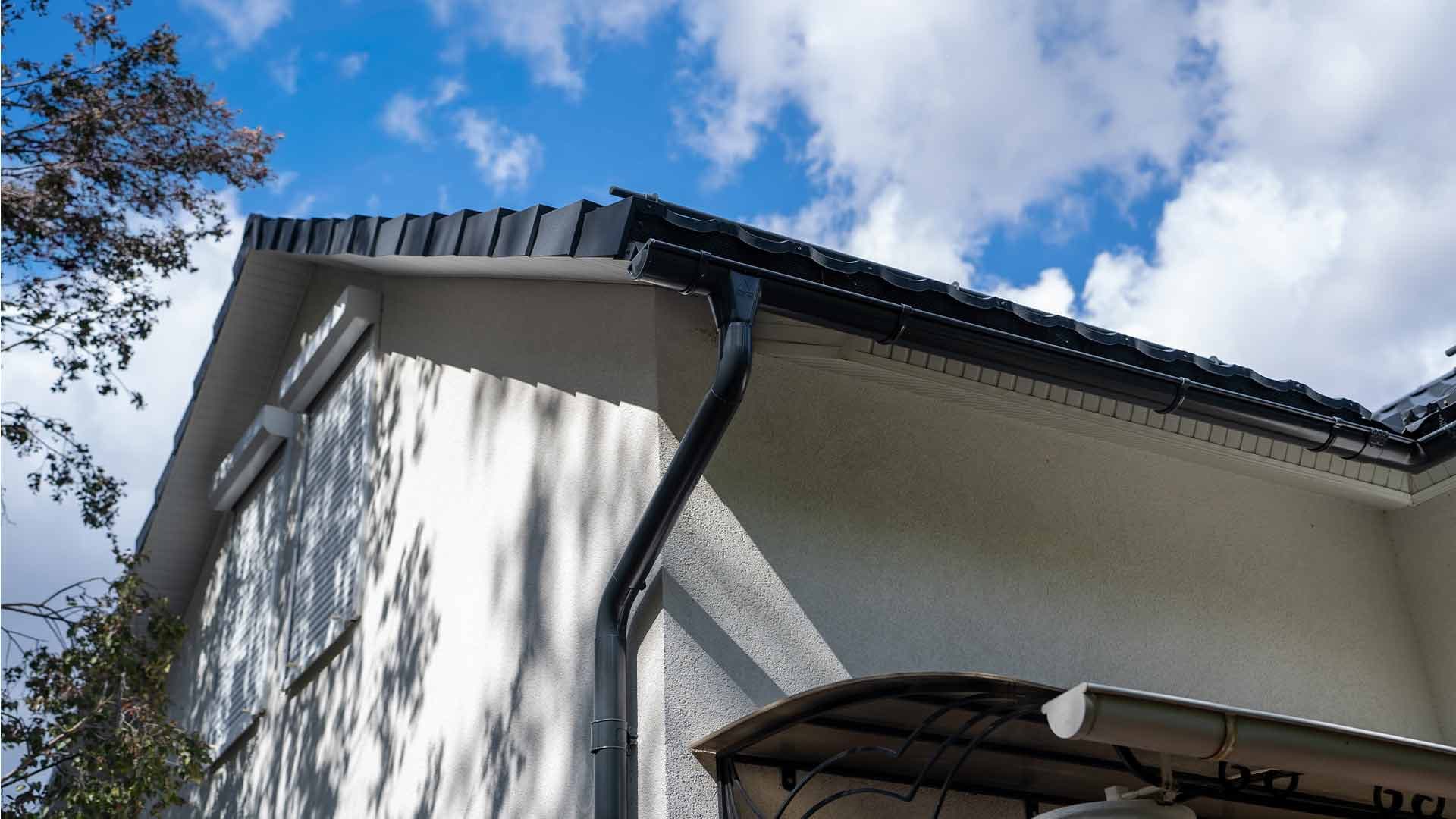 White fascias and soffits with dark guttering and a downpipe