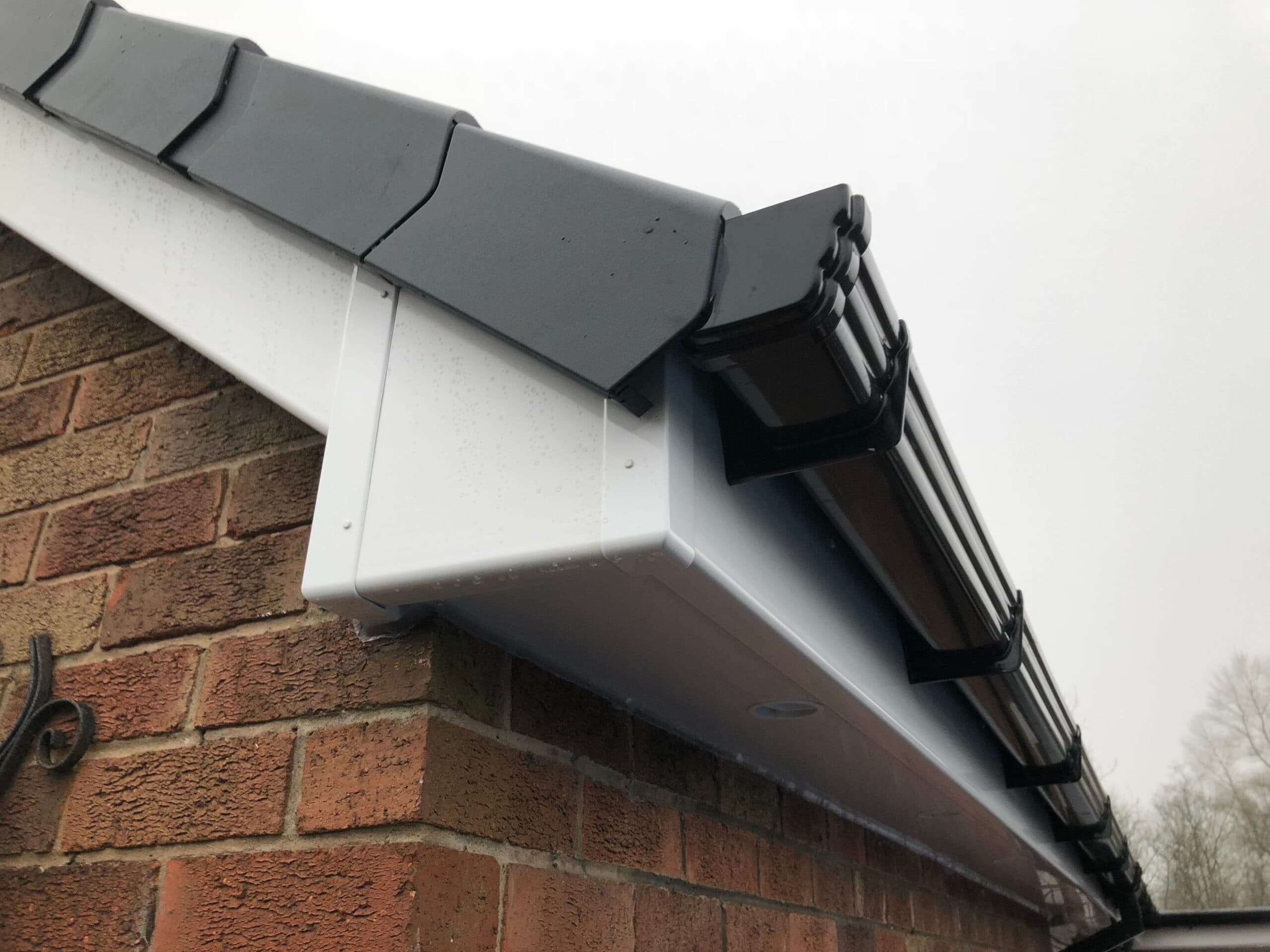 Interlocking dry verge caps along a gable edge above white fascia boards